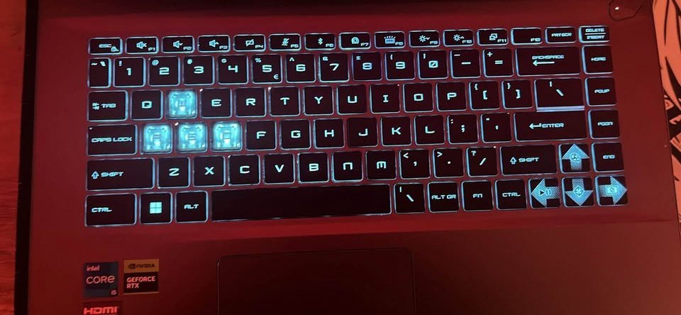 MSI Thin 15 gaming laptop keyboard with blue backlit keys and Intel Core i5 RTX stickers