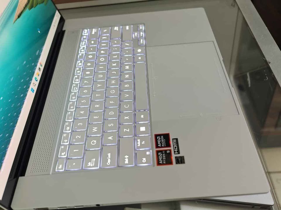 ASUS Zenbook S 16 laptop showcasing its backlit keyboard with white LED illumination and dual bottom-firing speakers.